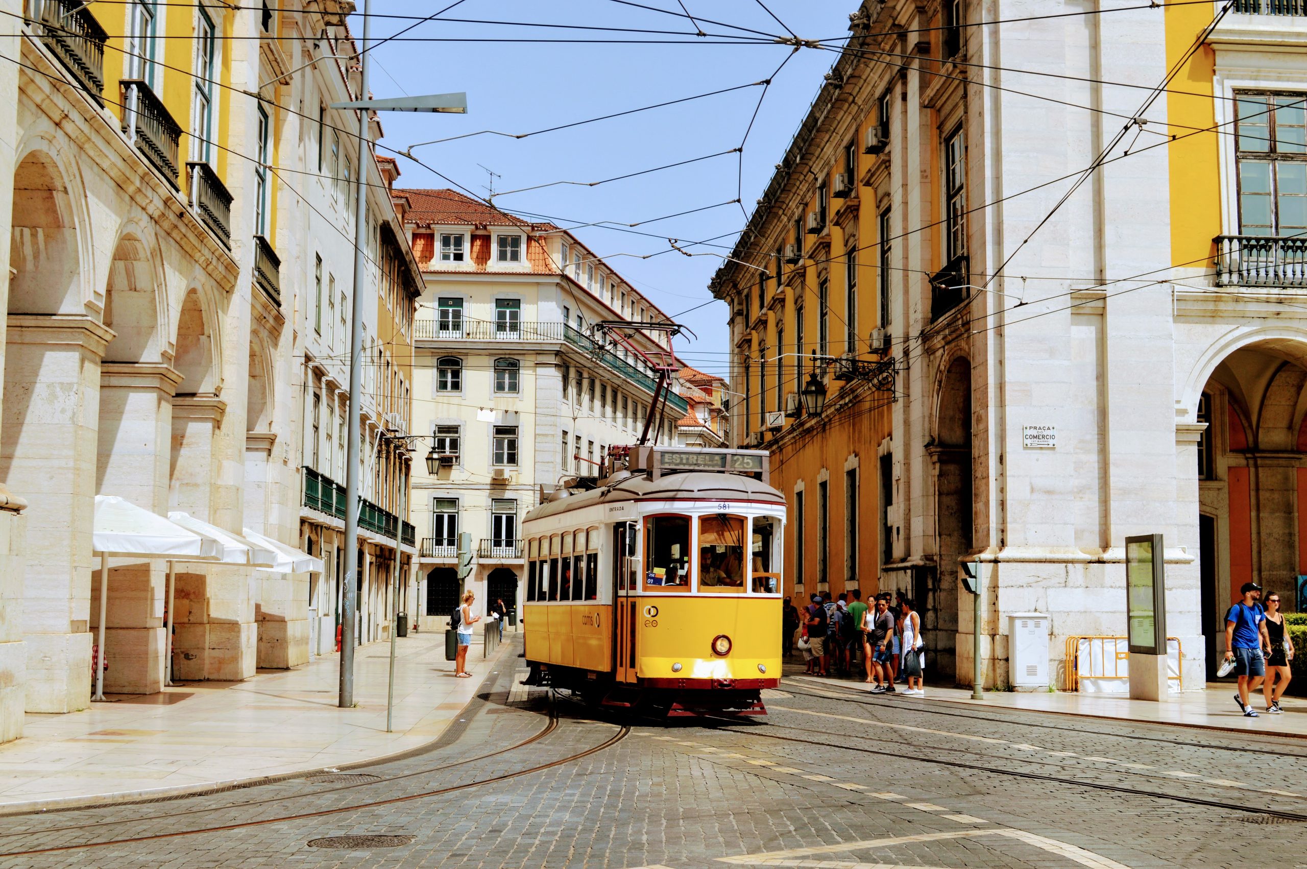 Imagem de capa para How to Portuguese, mostrando o elétrico 25 com destino Estrela na baixa de Lisboa.
